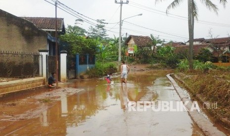 Lumpur sisa banjir memenuhi jalan di Kampung Cibadak, Kecamatan Baleendah, Kabupaten Bandung. (Foto: Ibnu Fauzi) 