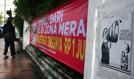  Pejalan kaki melintasi spanduk sosialisasi zona merah PKL di jalan Merdeka Bandung, Sabtu(1/2).   (Septianjar Muharam)