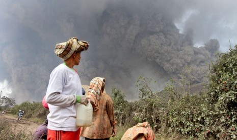 Warga menyaksikan erupsi Gunung Sinabung di Kabupaten Karo, Sumatera Utara, Sabtu (1/2).  (AP Photo)