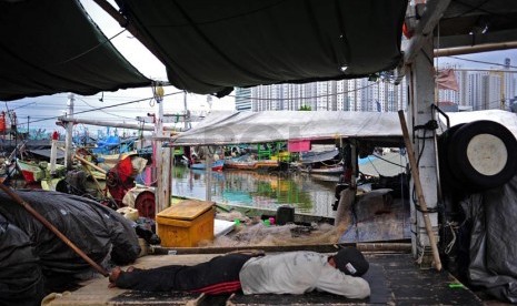   Nelayan beristirahat diatas kapalnya yang bersandar di Pelabuhan Muara Angke, Jakarta, Ahad (2/1).   (Republika/Adhi Wicaksono)