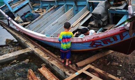 Nelayan memperbaiki kapalnya yang bersandar di Pelabuhan Muara Angke, Jakarta, Ahad (2/1).  (Republika/Adhi Wicaksono)