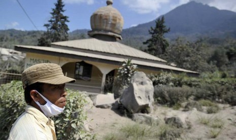   Seorang warga melintasi masjid yang diselimuti abu vulkanik Gunung Sinabung di Desa Mardinding, Karo, Sumut, Selasa (4/2).   (Antara/Wahyu Putro)