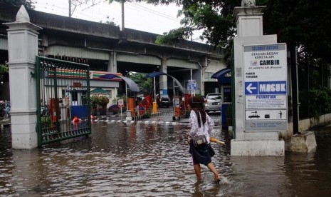  Warga melewati genangan air akibat air di Jalan Medan Merdeka Timur, Jakarta Pusat, Rabu (5/2). (Republika/Yasin Habibi)