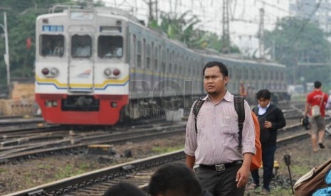  Penumpang KRL berjalan kaki melintasi rel saat terjadi gangguan operasional KRL yang hanya beroperasi hingga Stasiun Manggarai, Jakarta Selatan, Rabu (5/2). (Republika/Rakhmawaty La'lang)