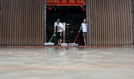   Karyawan toko membersihkan toko yang tutup akibat banjir di kawasan perdagangan Pasar Baru, Jakarta, Rabu (5/2).   (Republika/Aditya Pradana Putra)