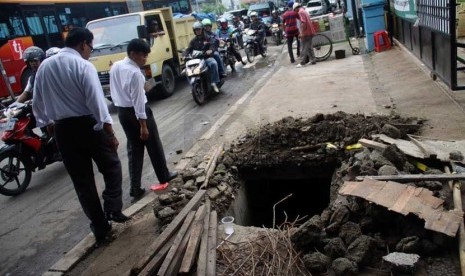   Warga melintasi trotoar yang ambles di Jalan Jatinegara Barat di depan gerbang pembangunan Rusun Jatinegara Barat, Jakarta, Kamis (4/2).      (Republika/Yasin Habibi)rat, Jakarta, Kamis (4/2).      (Republika/Yasin Habibi)