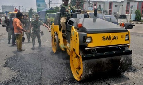  Prajurit TNI AD dan pekerja dengan bantuan alat berat melakukan penambalan jalan berlubang di jalur utama pantura, di Semarang, Jateng, Senin (10/2).   (Antara/R. Rekotomo)