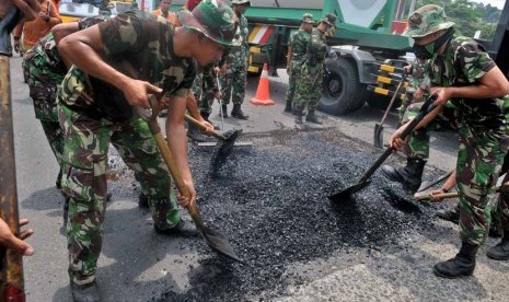  Prajurit TNI AD melakukan penambalan jalan berlubang di jalur utama pantura, di Semarang, Jateng, Senin (10/2).  (Antara/R. Rekotomo)