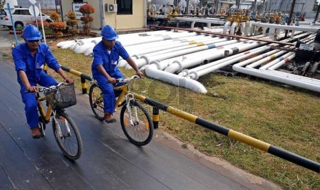  Pekerja dengan mengunakan sepda melintas di depan terminal pipa distribusi Bahan Bakar Minyak di Terminal Pompa BBM di Terminal BBM, Tanjung Uban, Kepulauan Riau, Rabu (12/2). (Republika/Prayogi)