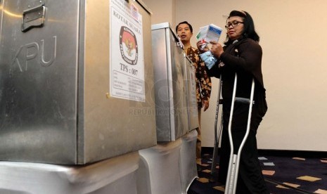   Penyandang disabilitas memasukan surat suara ke kotak suara pada simulasi Pemungutan dan Penghitungan Suara di TPS, Jakarta, Jumat (14/2).     (Republika/Tahta Aidilla)