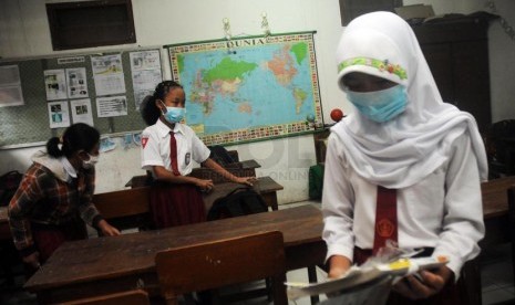  Siswa SDN Banjaran VI Kediri, Jawa Timur, Senin (17/2), dengan menggunakan masker mulai kembali bersekolah.    (Republika/Adhi Wicaksono)