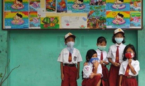  Siswa SDN Banjaran VI Kediri, Jawa Timur, Senin (17/2), dengan menggunakan masker mulai kembali bersekolah.    (Republika/Adhi Wicaksono)