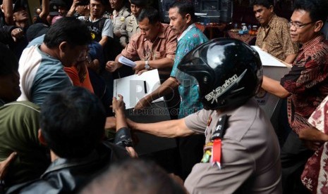  Petugas kepolisian mengamankan kotak suara dari amukan demontran saat simulasi pemilu di depan kantor KPU Jakarta Selatan, Jumat (21/2).  (Republika/Agung Supriyanto)