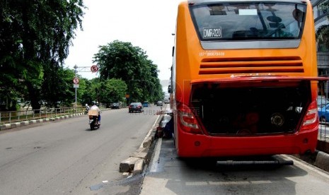  Seorang petugas memperbaiki bus TransJakarta yang mogok di Jalan Gunung Sahari Raya, Jakarta Pusat, Selasa (25/2). (foto: Raisan Al Farisi)