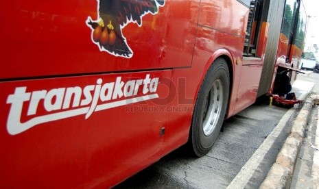  Seorang petugas memperbaiki bus TransJakarta yang mogok di Jalan Gunung Sahari Raya, Jakarta Pusat, Selasa (25/2). (foto: Raisan Al Farisi)