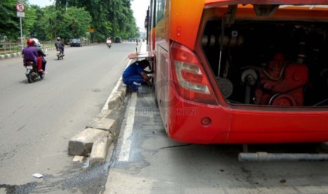  Seorang petugas memperbaiki bus TransJakarta yang mogok di Jalan Gunung Sahari Raya, Jakarta Pusat, Selasa (25/2). (foto: Raisan Al Farisi)