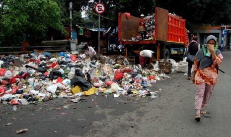 Seorang pengguna jalan melintasi sampah yang berserakan di bahu Jalan Matraman Raya, Jakarta Timur, Rabu (26/2).   (foto: Raisan Al Farisi)