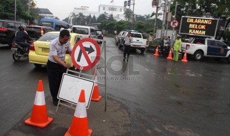   Petugas memasang rambu-rambu lalu lintas saat melakukan rekayasa lalu lintas di perempatan Kota Tua, Jakarta, Rabu (26/2).   (Republika/Yasin Habibi)