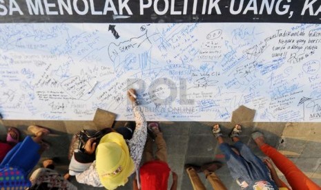  Warga menandatangani spanduk petisi di sela deklarasi kampanye Tolak Politik Uang di Plaza Teater Jakarta, TIM Cikini, Jakarta, Jumat (28/2).   (Republika/Aditya Pradana Putra)