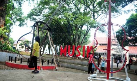   Seorang pengunjung memperhatikan ornamen gitar di Taman Musik Jalan Belitung Bandung, Ahad (2/3). (foto : Septianjar Muharam)