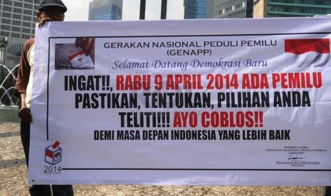    Relawan dari Gerakan Nasional Peduli Pemilu (Genapp) merentangkan spanduk sosialisasi Pemilu 2014 di Bundaran HI, Jakarta, Selasa (4/3). (Republika/Tahta Aidilla)