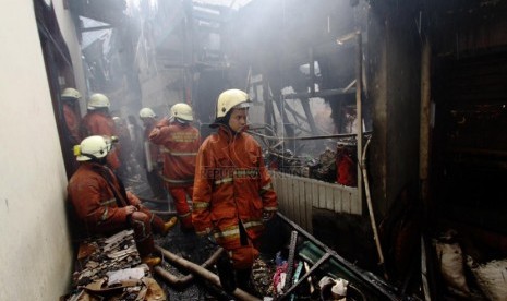  Petugas pemadam kebakaran memadamkan api saat kebakaran melanda permukiman padat di kawasan Jembatan Besi, Tambora, Jakarta Barat, Jumat (7/3).  (Republika/Yasin Habibi)