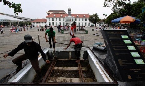   Pekerja membongkar tutup Monumen Jalur Trem yang ada di kawasan Kota Tua, Jakarta Barat, Senin (10/3).   (Republika/Yasin Habibi)