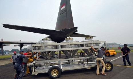   Sejumlah petugas membawa tangki berisi garam untuk dinaikkan ke pesawat Hercules C-130 di Lanud Halim Perdana Kusuma Jakarta, Sabtu (15/3).  (Antara/Wahyu Putro)