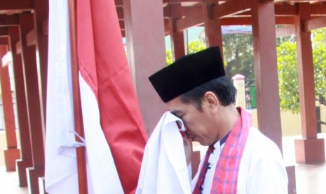 Gubernur DKI Jakarta Joko Widodo mencium bendera Merah Putih seusai diumumkan sebagai  Capres PDIP, di Rumah Pitung, Marunda, Jakarta Utara (14/3). (Antara/Heru)