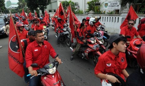   Para simpatisan Partai Demokrasi Indonesia Perjuangan (PDIP) berkonvoi dengan sepeda motor saat kampanye perdana di depan Museum Kebangkitan Nasional, Jakarta, Ahad (16/3).(Republika/Aditya Pradana Putra)