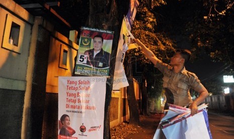 Petugas Kamtibmas Bambu Apus melakukan penertiban atribut kampanye yang dipasang di sembarang tempat di kawasan Bambu Apus, Jakarta Timur, Sabtu (22/3).  (Republika/Edwin Dwi Putranto)