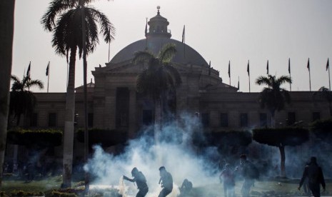  Pendukung Presiden terguling Muhammad Mursi mengambil tabung gas air mata yang ditembakkan oleh pasukan keamanan di Universitas Kairo, Giza, Mesir, Rabu (26/3).  (AP/Amru Taha)