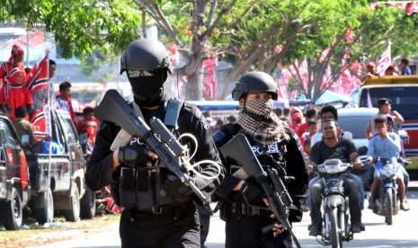   Dua personel polisi dari unit Gegana bersenjata lengkap menjaga kawasan kampanye Partai Aceh (PA) di lapangan Rancong, Muara Satu, Lhokseumawe, Aceh, Rabu (2/4).  (Antara/Rahmad)