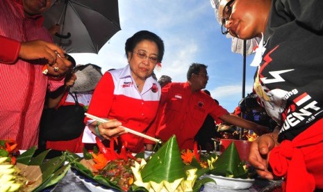 Ketua Umum PDI Perjuangan Megawati Soekarno Putri (tengah) mencicipi makanan saat lomba masakan tradisional Bali di Lapangan Busungliu, Buleleng, Bali, Kamis (3/4). (Antara/Zabur Karuru)