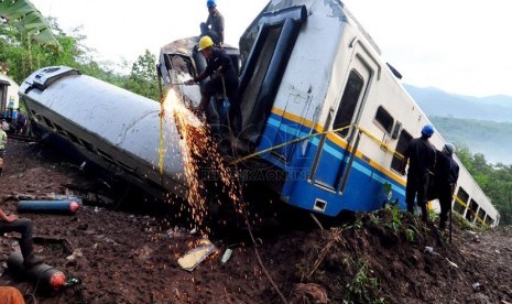   Pekerja mengevakuasi kereta api Malabar jurusan Bandung - Malang yang terperosok jurang untuk di evakuasi di Kampung  Cikerung,  Desa Mekarsari, Kecamatan Kadipaten, Tasikmalaya, Sabtu (5/4). (foto: Septianjar Muharam)