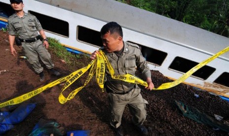  Petugas memasang garis polisi di lokasi terperosoknya kereta api Malabar jurusan Bandung - Malang yang di Kampung  Cikerung,  Desa Mekarsari, Kecamatan Kadipaten, Tasikmalaya, Sabtu (5/4). (foto: Septianjar Muharam)