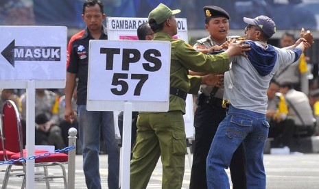  Petugas kepolisian serta linmas berusaha menenangkan warga yang tidak dapat menggunakan hak suaranya ketika simulasi pengamanan tempat pemungutan suara (TPS) di Mapolda Metro Jaya Jakarta, Senin (7/4).  (Antara/Wahyu Putro)