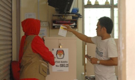 Seorang WNI yang menetap di Malaysia mencoblos di bilik suara dalam Pemilihan Legislatif yang dilaksanakan di Sekolah Indonesia Kuala Lumpur, Malaysia, Ahad (6/4).  (Antara/Rafiuddin Abdul Rahman)