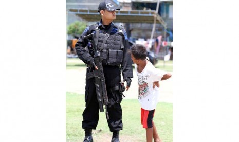    Seorang anak melihat dari dekat persenjataan aparat keamanan yang berjaga di kawasan rawan pemilu, Desa Pusong, Lhokseumawe, Provinsi Aceh, Selasa (8/4). (Antara/Rahmad)