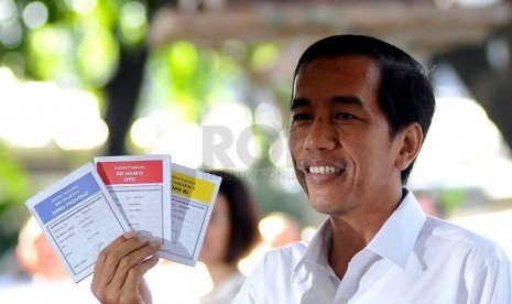 Gubernur DKI Jakarta, Joko Widodo menunjukkan surat suara saat mencoblos di TPS 27 Menteng, Jakarta Pusat, Rabu (9/4). (Republika/Prayogi)