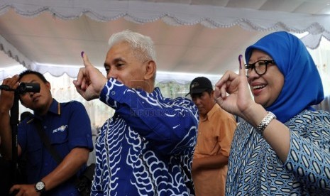   Menteri Koordinator Perekonomian Hatta Rajasa, bersama istri Oktiniwati Ulfa Dariah Rajasa mencoblos di Desa Jejawi, Kecamatan Jejawi, Kabupaten Ogan Komering Ilir (OKI), Rabu (9/4). (Republika/Maspril Aries)