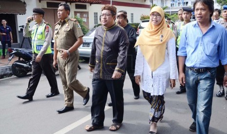   Gubernur Jabar, Ahmad Heryawan bersama istri berjalan menuju TPS 1 di Keluarahan Babakan Ciamis, Kota Bandung, Rabu (9/4). (Republika/Edi Yusuf)