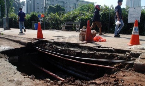   Lubang akibat jalan yang amblas di sekitar Halte Bus TransJakarta Polda Metro Jaya, Semanggi, Jakarta Pusat, Jumat (11/4). (Republika/Yasin Habibi)