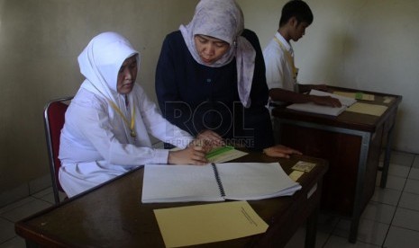   Siswa penyandang tuna netra Novitriyani (kiri), dan Ikhsanegi Ramadhan (kanan) mengikuti Ujian Nasional di SLB Bagian-A (Tuna Netra) Pembina Tingkat Nasional, Jakarta Selatan, Senin (14/4).(Republika/Yasin Habibi)