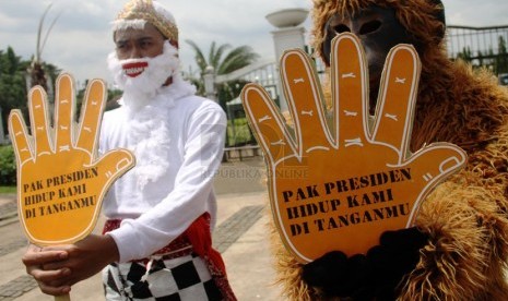   Aktivis orangutan dari Center for Orangutan Protection menggelar aksi dengan mengenakan kostum orangutan dan tokoh wayang Hanoman di depan Istana Merdeka, Jakarta, Rabu (16/4). (Republika/Yasin Habibi)