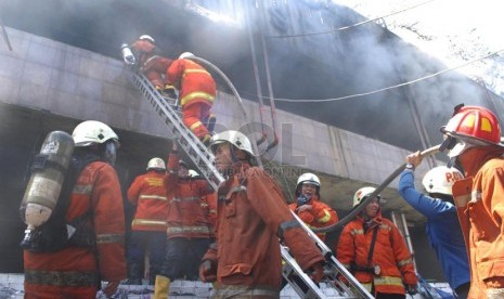 Petugas pemadam kebakaran berusaha untuk memadamkan api yang melalap sejumlah kios di Pasar Senen, Jakarta Pusat, Jumat (25/4). (Republika/Rakhmawaty La'lang)