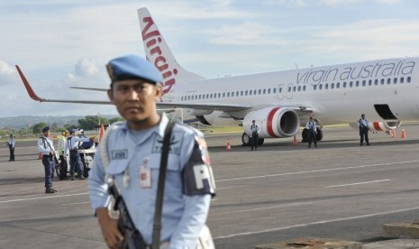 Sejumlah personel TNI AU berjaga di samping pesawat Virgin Australia menyusul adanya informasi pembajakan, setibanya di Bandara Ngurah Rai, Denpasar, Jumat (25/4). (Antara/Nyoman Budhiana)