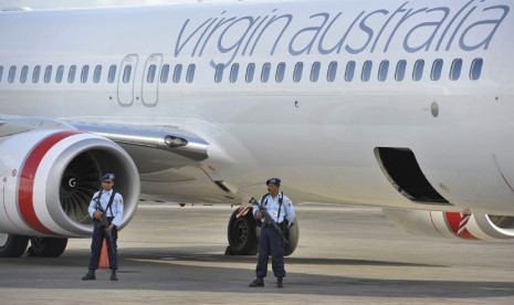 Sejumlah personel TNI AU berjaga di samping pesawat Virgin Australia menyusul adanya informasi pembajakan, setibanya di Bandara Ngurah Rai, Denpasar, Jumat (25/4). (Antara/Nyoman Budhiana)