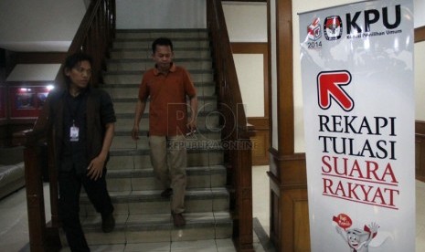   Peserta rapat melintas di depan ruang Rapat Pleno Terbuka Rekapitulasi Nasional Penghitungan Suara Pemilu DPR & DPD tahun 2014 di ruang sidang utama KPU, Jakarta, Ahad (27/4). (Republika/Yasin Habibi)