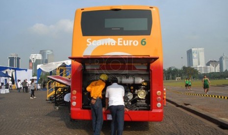   Sejumlah tamu undangan melihat bagian mesin Bus Scania Euro 6 saat melakukan uji coba melintas di Jalan Jendral Sudirman, Jakarta Pusat, Kamis (8/5). (Republika/Rakhmawaty La'lang)